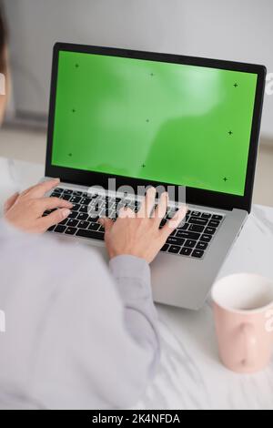 Laptop with black green screen and hands of creative webdesigner typing on keypad while working over new website or application Stock Photo