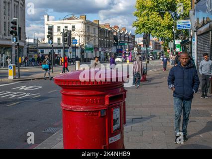 London, UK. Sept 29 2022 . Workers Union take further national strike action. Man walks by Traditional red post box in Lewisham,London ,England . Stock Photo