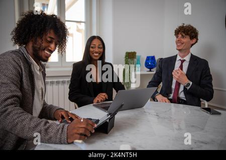 Multiracial colleagues sitting around the table in the office discuss work. Stock Photo