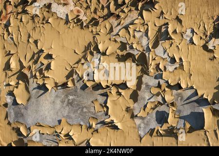 Metal background with cracked paint. The texture of the exfoliating paint of the paint. Background of old painted metal. Peeling paint on metal. Stock Photo