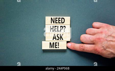 Support and need help ask me symbol. Concept words Need help ask me on wooden blocks on a beautiful grey table grey background. Businessman hand. Busi Stock Photo