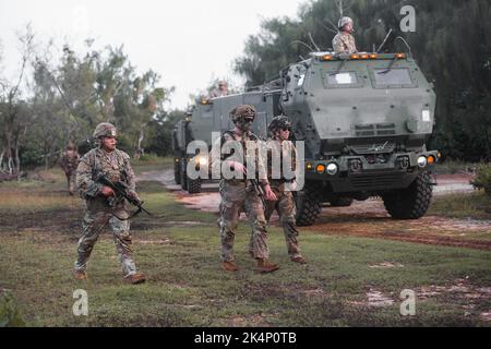 U.S. Army Soldiers assigned to Alpha Company, 2nd Battalion, 27th Infantry Regiment, 3rd Infantry Brigade Combat Team, 25th Infantry Division escort four Hight Mobility Artillery Rocket System vehicles belonging to 1st Battalion, 94th Field Artillery Regiment, 17th Field Artillery Brigade to their firing positions at Andersen Air Force Base, Guam, Sept. 26, 2022. The training exercise between the two units demonstrates Alpha Company's ability to clear and secure a space for the HIMARS to conduct its firing missions. Stock Photo