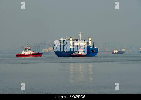 Tugboat and transportation ship maneuver in Tanjung Perak port, Surabaya, Indonesia, August 2022 Stock Photo