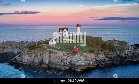 “Cape Neddick Lighthouse Sunset” The Cape Neddick Lighthouse stands on Nubble Island about 100yd off Cape Neddick Point. It is commonly known as Nubbl Stock Photo