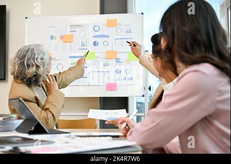 Professional Asian businesspeople or financial analysts team working, discussing and brainstorming on their business financial plan in the meeting. Stock Photo