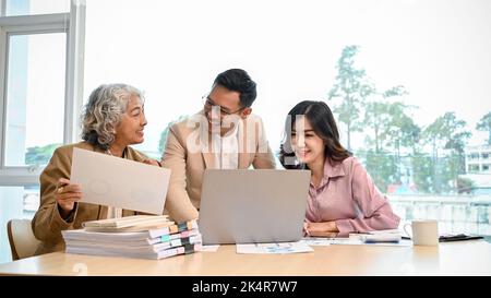 Smart and professional Asian businesspeople working together, sharing ideas and brainstorming on their business project in the meeting. Stock Photo