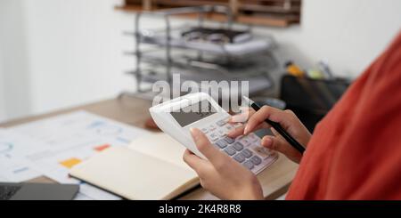 Close up hands businessman doing finances with using calculator for debt or tax. Stock Photo