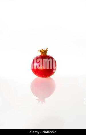 Ripe red pomegranate with reflection, isolated on a white background Stock Photo