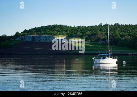 A boat sailing in Penobscot River in front of Fort Knox State Park, Prospect, Maine Stock Photo