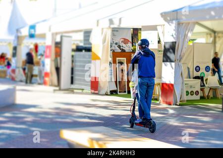 Dad with his daughter on an electric scooter riding. Stock Photo