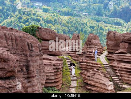 Chongqing, China's Chongqing Municipality. 3rd Oct, 2022. Tourists visit a red stone forest geopark in Youyang Tujia and Miao Autonomous County, southwest China's Chongqing Municipality, Oct. 3, 2022. The Youyang red stone forest geopark, which has the karst landform, opened to the public during the National Day holiday. Credit: Liu Chan/Xinhua/Alamy Live News Stock Photo