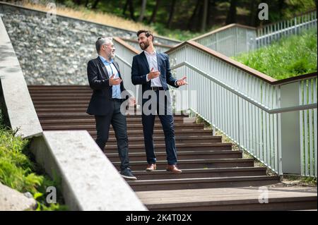 Two businessmen walking down the stairs and talking Stock Photo