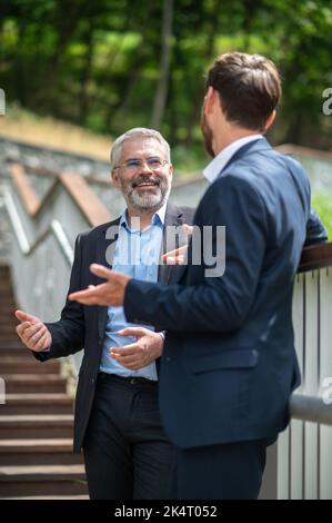 Two businessmen discussing the project details and looking involved Stock Photo
