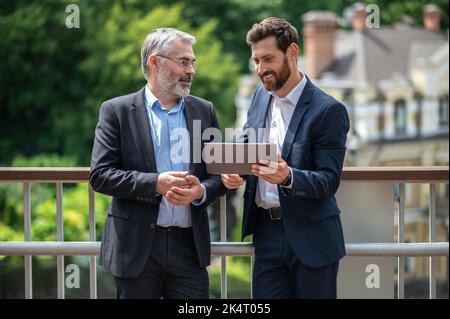 Two businessmen discussing the project details and looking involved Stock Photo