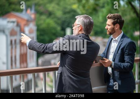 Two businessmen discussing the project details and looking involved Stock Photo