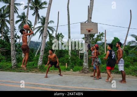 Port Barton, Philippines - May 2022: People playing basketball in the middle of the road in Port Barton on May 16, 2022 in Palawan Island, Philippines Stock Photo