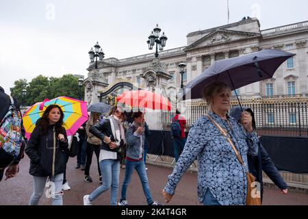 Members of the public are undeterred by the wet weather to file past Buckingham Palace towards Green Park to lay flowers following the death of Queen Elizabeth II, and the proclamation of the new King Charles III on 13th September 2022 in London, United Kingdom. The scale and volume of flowers that have been left in memorial to the Queen shows the depth of feeling that people have for the deceased monarch. Stock Photo