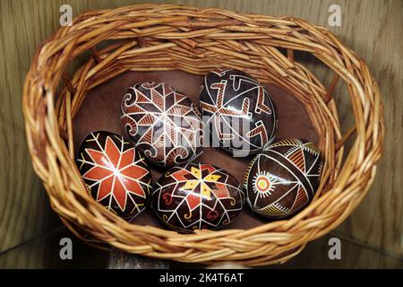 Hand painted ukrainian Easter eggs in wicker basket. Egg decorating in Slavic culture. Stock Photo