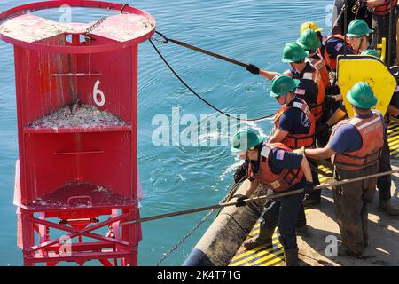 Portland, Maine, USA. 28th July, 2022. Crewmembers from Coast Guard Cutter Marcus Hanna begin servicing a buoy by hooking the buoy to bring it aboard July 28, 2022. The team's mission is to service, inspect, and replace navigational aids in the Northeast that may be due for maintenance, have been displaced, damaged, or are at the end of its hull life. USCGC Marcus Hanna is responsible for a total of 376 aids to navigation. Credit: U.S. Coast Guard/ZUMA Press Wire Service/ZUMAPRESS.com/Alamy Live News Stock Photo