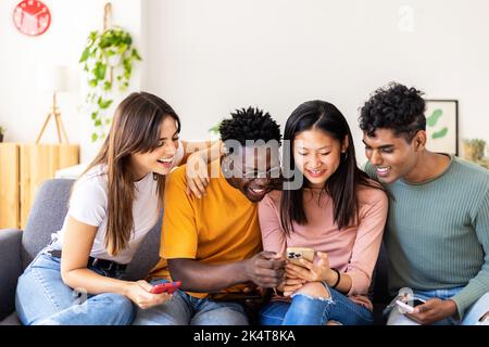 Young millennial group of multiracial friends having fun using mobile phone Stock Photo