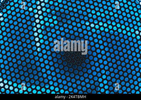 Blue light shines through the ventilation grid holes of computer air cooling system. abstract background Stock Photo