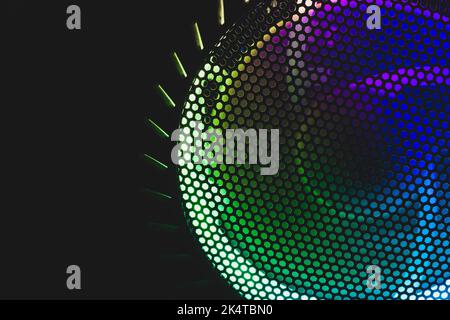 Colorful led lights of computer fan shines through the protective grid. illumination glows in the dark. abstract futuristic background Stock Photo