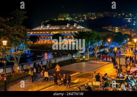 Tourists enjoy the promenade and al fresco dining of Stanley waterfront at night, with Murray House and a setting new moon, Hong Kong Island Stock Photo