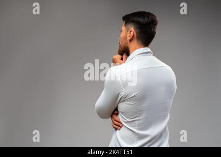 Studuo shot of thinking businessman standing over gray background Stock Photo