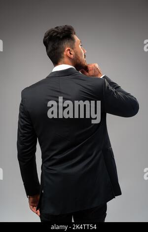 Studuo shot of thinking businessman standing over gray background Stock Photo