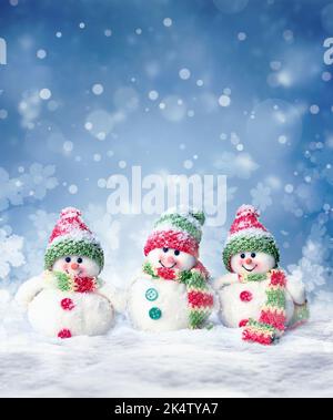 Cute three white snowmen standing at the snowy ground background Stock ...