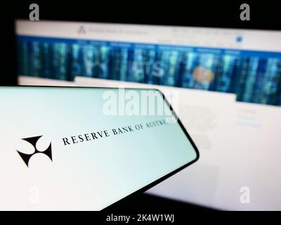 Smartphone with logo of issuer Reserve Bank of Australia (RBA) on screen in front of business website. Focus on center-left of phone display. Stock Photo
