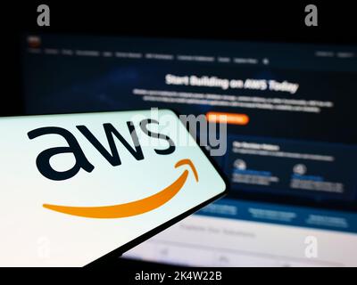 Mobile phone with logo of US cloud company Amazon Web Services Inc. (AWS) on screen in front of website. Focus on center-left of phone display. Stock Photo