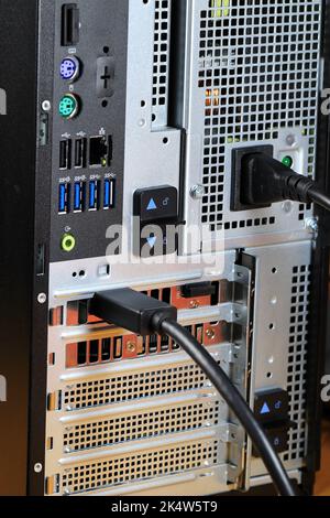 Close up of AC power and display port cable plugged into the back of desktop PC or workstation. Stock Photo