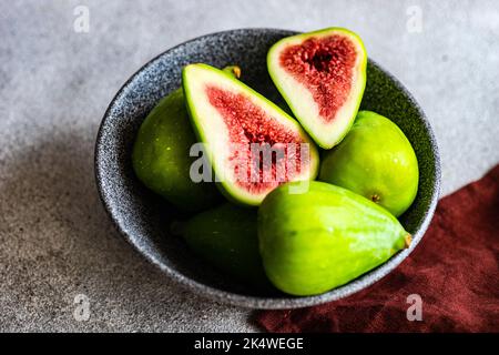 Close-up of a bowl of ripe green figs on a table with a napkin Stock Photo