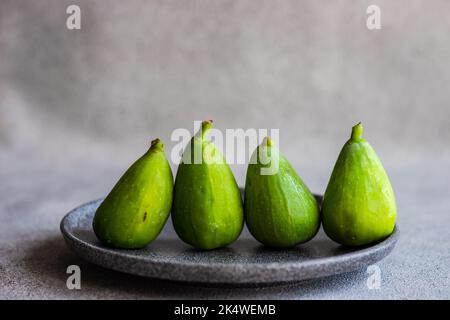 Close-Up of four ripe green figs on a plate Stock Photo