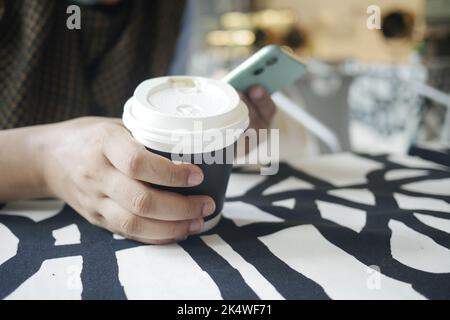 women hand holding smart phone and paper coffee cup  Stock Photo