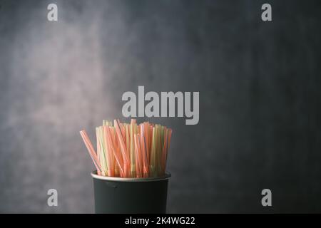 Colored striped bright plastic straws in a jar  Stock Photo