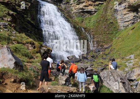 PYRENEES, SPAIN - SEPTEMBER 25, 2021: Tourists visit a waterfall named Cascada de la Cola de Caballo in Ordesa y Monte Perdido National Park in Pyrene Stock Photo
