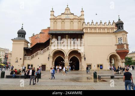 KRAKOW, POLAND - JULY 3, 2021: People visit Rynek square on a rainy day in Krakow, Poland. The Historic Centre of Krakow is a UNESCO World Heritage Si Stock Photo