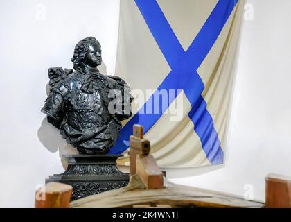 Medieval bust of Russian Tsar Peter the Great next to the old Russian naval flag and blurred details of a wooden boat, in Pereslavl-Zalessky, Russia Stock Photo