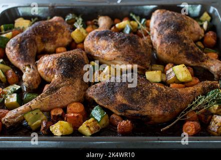 Homemade oven baked Chicken with roasted vegetables on a baking tray Stock Photo