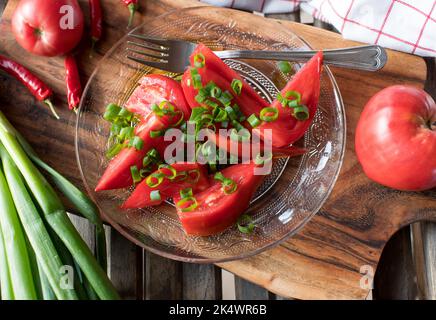 Tomato salad with beefsteak tomatoes, chives and olive oil Stock Photo