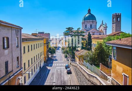 The top view of Salita della Memoria street with old houses roofs, Torre del Pegol tower of Palazzo Broletto and dome of New Cathedral (Duomo Nuovo), Stock Photo