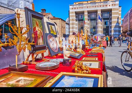 BRESCIA, ITALY - APRIL 10, 2022: The counters of the flea market with vintage tableware, icons, paintings, candlesticks and statuettes, Victory Square Stock Photo