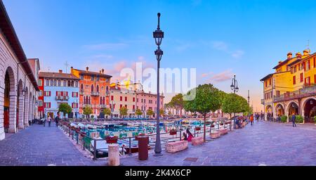 Enjoy the evening walk in Porto Vecchio (Old Port) with colored mansions around the port, Desenzano del Garda, Lake Garda, Italy Stock Photo
