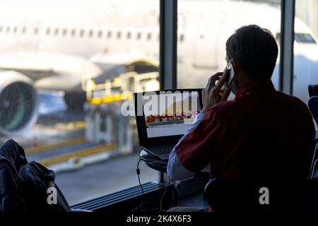 Traveling businessman working with laptop and using smartphone in the airport lounge Stock Photo