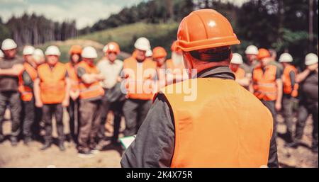 Worker group wearing vest, safety. Building concept. Architector, engineers on constructing site. Builder man Stock Photo