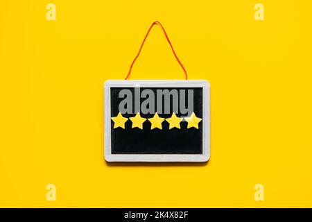 Customer Experience, Review Concept. Five yellow stars excellent rating in frame on yellow background. Customers Ratings and Reviews Stock Photo