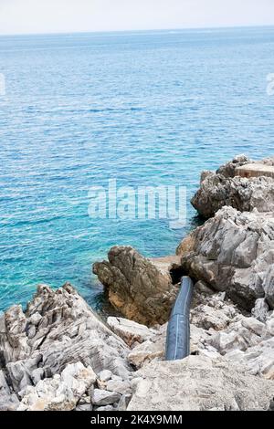 Long black pipe pollute the sea and water with toxic waste. Environmental conservation concept Stock Photo