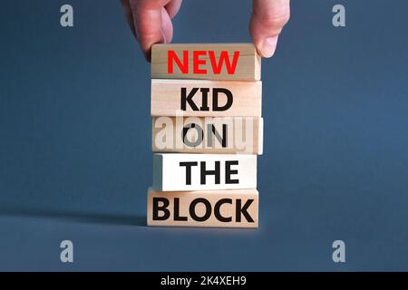 New kid on the block symbol. Concept words New kid on the block on wooden blocks. Businessman hand. Beautiful grey table grey background. Business and Stock Photo